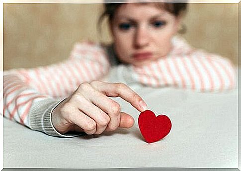 Sad woman touching a heart representing magnetic spirits