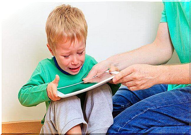 A child crying to keep his tablet. 