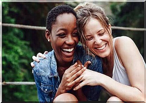 Two girlfriends laughing together.